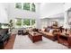 Open-concept living room with lots of natural light, hardwood floors, and comfortable leather seating at 7327 Snowbird Ct, Mint Hill, NC 28227