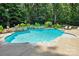 Beautiful in-ground pool with a rock wall waterfall feature surrounded by lush landscaping at 7327 Snowbird Ct, Mint Hill, NC 28227