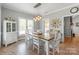 Charming dining room featuring rustic wooden table, white chairs, and stylish light fixture at 773 Hathcock Glen Dr, Oakboro, NC 28129