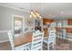 Bright dining area featuring a long wooden table, chairs, modern pendant lighting, and an open layout to the kitchen at 773 Hathcock Glen Dr, Oakboro, NC 28129