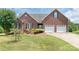 Charming red brick home boasts a manicured lawn, mature landscaping, and an attached two-car garage at 773 Hathcock Glen Dr, Oakboro, NC 28129