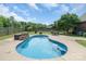 Backyard pool area with stone fireplace, table and chairs surrounded by trees at 773 Hathcock Glen Dr, Oakboro, NC 28129