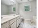 Bright bathroom with double sink vanity, a large mirror and marble-style tile floors at 8701 Holly Creek Ct, Charlotte, NC 28216