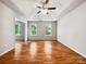 Spacious bedroom featuring hardwood floors, ceiling fan, and abundant natural light from multiple windows at 8701 Holly Creek Ct, Charlotte, NC 28216