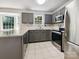 Modern kitchen featuring stainless steel appliances, gray cabinets and tile flooring at 8701 Holly Creek Ct, Charlotte, NC 28216