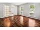 Home office featuring hardwood floors, glass doors, and windows offering abundant natural light at 8701 Holly Creek Ct, Charlotte, NC 28216