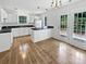 Well-lit kitchen with white cabinets, black countertops, hardwood floors, and a door leading to the backyard at 9121 Charminster Ct, Charlotte, NC 28269