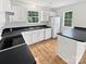 The kitchen is equipped with white cabinets, black countertops, and stainless steel appliances, providing a clean and functional space at 9121 Charminster Ct, Charlotte, NC 28269