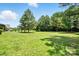 Sprawling backyard with lush green grass and mature trees offering ample space for outdoor activities at 1006 Spring Rose Ln, Matthews, NC 28104