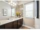 Bathroom featuring double sinks, a large mirror, tiled accent wall, and granite countertops at 1006 Spring Rose Ln, Matthews, NC 28104