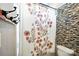 Bathroom showing a tile backsplash, a shower curtain, and a neutral colored toilet at 1006 Spring Rose Ln, Matthews, NC 28104