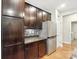 Kitchen with stainless steel refrigerator, wooden cabinets, mosaic backsplash, and hardwood floors at 1006 Spring Rose Ln, Matthews, NC 28104