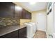 Laundry room featuring dark cabinets, a tile backsplash, and modern appliances at 1006 Spring Rose Ln, Matthews, NC 28104