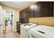 Laundry room with modern washer and dryer, cabinets, and tile backsplash at 1006 Spring Rose Ln, Matthews, NC 28104
