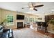 Bright living room with fireplace, hardwood floors, ceiling fan, and seamless flow to kitchen at 1006 Spring Rose Ln, Matthews, NC 28104