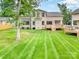Back exterior view of home featuring a brick facade, lush lawn, and a wooden deck at 101 Mcalway Rd, Charlotte, NC 28211