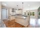 Bright kitchen featuring a central island, stainless steel range hood, and hardwood floors, offering a chef-inspired space at 101 Mcalway Rd, Charlotte, NC 28211