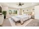Bright main bedroom featuring a plush bed, a bench, large windows, and neutral tones, creating a peaceful retreat at 101 Mcalway Rd, Charlotte, NC 28211