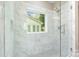 This pristine bathroom boasts a glass shower with marble-patterned tile and a window view at 101 Mcalway Rd, Charlotte, NC 28211