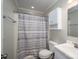 Bathroom with toilet, shower with striped curtain, white sink, cabinets, and mirror at 108 Graham St, Stanley, NC 28164