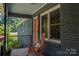 Inviting front porch featuring a cozy rocking chair, an orange front door, and black railings at 108 Graham St, Stanley, NC 28164
