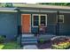 Inviting front porch featuring a cozy rocking chair, an orange front door, and black railings at 108 Graham St, Stanley, NC 28164