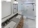 Modern bathroom featuring double sinks, wood vanity, and a glass-enclosed shower at 10934 Coachman Cir, Charlotte, NC 28277
