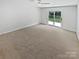 Neutral bedroom with a ceiling fan, carpet, and sliding glass door to the patio at 10934 Coachman Cir, Charlotte, NC 28277