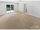 Neutral bedroom with a ceiling fan, carpet, and sliding glass door to the patio at 10934 Coachman Cir, Charlotte, NC 28277