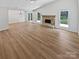 Open-concept floorplan includes a stone fireplace, wood floors, and views of the yard at 10934 Coachman Cir, Charlotte, NC 28277