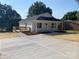 Inviting home featuring fresh landscaping, a well-kept lawn, and a cozy front porch at 1103 Adams St, Statesville, NC 28677