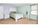 Bright bedroom featuring a white bed frame, nightstand, and mirror, bathed in natural light at 1288 Century Dr, Clover, SC 29710