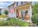 Charming front porch with rocking chairs, flowers, and an American flag at 1288 Century Dr, Clover, SC 29710