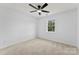 Bright bedroom features neutral carpet, a ceiling fan, and a window view at 12914 Sickles Dr, Charlotte, NC 28273