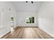 Bright and airy living room featuring light wood floors, a large window and freshly painted white walls at 12914 Sickles Dr, Charlotte, NC 28273