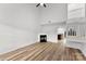 Bright, modern living room featuring a fireplace, ceiling fan, and beautiful light wood floors at 12914 Sickles Dr, Charlotte, NC 28273