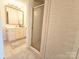 Bright bathroom with white cabinets, large mirror, glass shower, and tile flooring at 1323 Queens Rd # 327, Charlotte, NC 28207