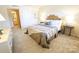 Bright bedroom with a rattan headboard, and a glimpse into the adjacent bathroom at 1323 Queens Rd # 327, Charlotte, NC 28207