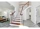 Bright entryway with a wooden staircase, neutral paint colors, and wood-look tile flooring at 1427 Rosemont Dr, Indian Land, SC 29707