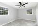 A bright bedroom with two windows, gray walls, light floors and a ceiling fan at 1655 Woodhaven Rd, Rock Hill, SC 29732