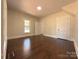 Cozy bedroom with hardwood floors, neutral paint, a window for natural light, and two entry doors at 179 Duval Nw St, Concord, NC 28025