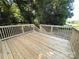 Wooden deck with railing provides a backyard view, surrounded by lush trees at 179 Duval Nw St, Concord, NC 28025