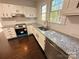 Modern kitchen boasts white cabinets, subway tile backsplash, and stainless steel appliances at 179 Duval Nw St, Concord, NC 28025