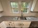 Kitchen sink and granite countertop with white cabinetry and natural light at 179 Duval Nw St, Concord, NC 28025