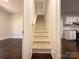 View of staircase and adjoining rooms, featuring fresh paint and new carpet at 179 Duval Nw St, Concord, NC 28025