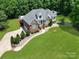 Aerial view of brick home with a large yard, driveway, landscaping, and an outbuilding on a well-manicured lawn at 1842 Caroline Way, Fort Mill, SC 29715