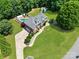 Aerial view of brick home with a large yard, in-ground pool, driveway, landscaping, and an outbuilding at 1842 Caroline Way, Fort Mill, SC 29715