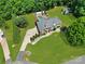 Aerial view of brick home with a large yard, in-ground pool, driveway, landscaping, and an outbuilding at 1842 Caroline Way, Fort Mill, SC 29715