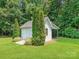 Charming outbuilding with double doors, offering additional storage or workshop space amidst lush landscaping at 1842 Caroline Way, Fort Mill, SC 29715
