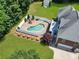 Aerial view of private in-ground pool surrounded by brick pavers and white fence; landscaped backyard and patio at 1842 Caroline Way, Fort Mill, SC 29715